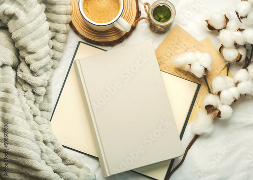 Top view of books with space for text ,cup of coffee and cotton flowers. Selective focus