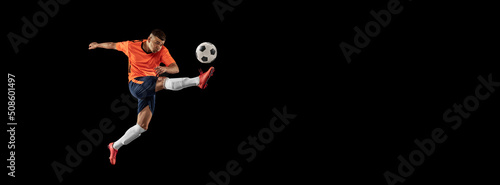 Flyer. Dynamic portrait of professional male football soccer player in motion isolated on dark background. Concept of sport, goals, competition, hobby, achievements photo