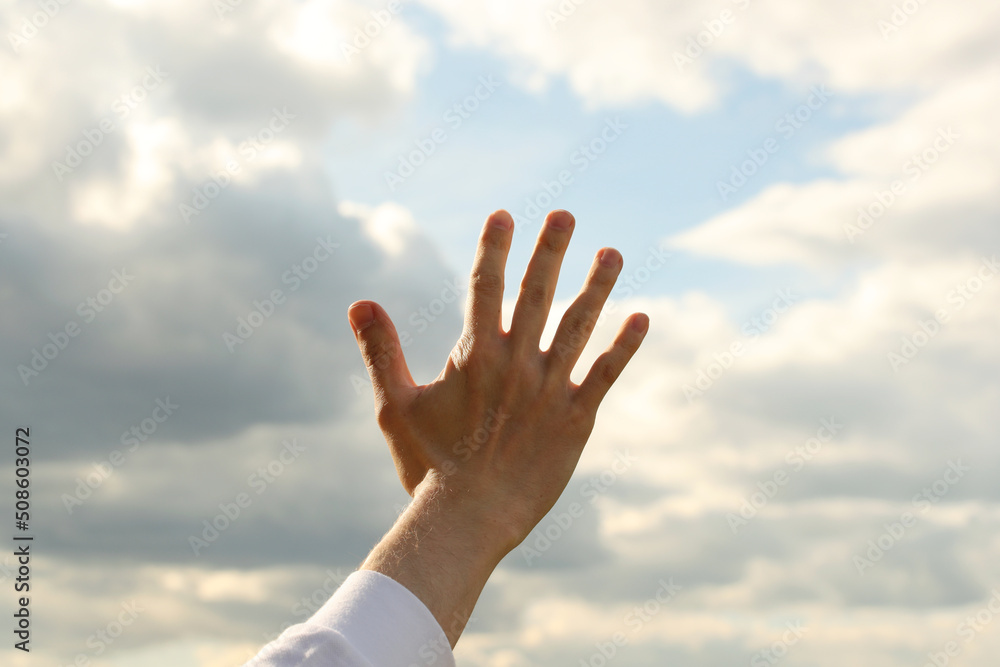Young man right hand and sky with clouds. Photo was taken 19 May 2022 year, MSK time in Russia. Young man right hand and sky with clouds. Photo was taken 19 May 2022 year, MSK time in Russia.