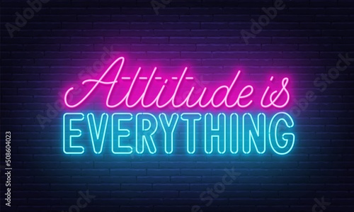 Attitude is everything neon quote on a brick wall.