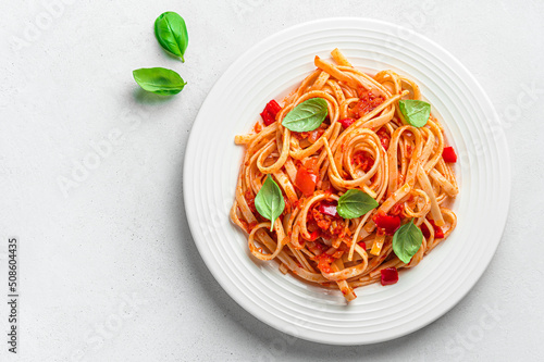Linguini pasta with tomato sauce and basil on a gray background with a copy space. Italian pasta.