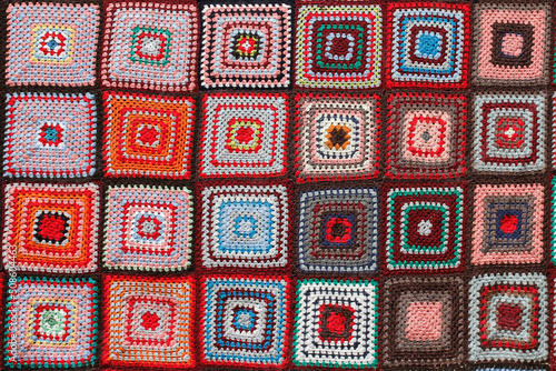 Detail of a crocheted patchwork multicolor wool blanket. photo