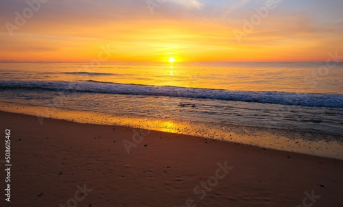 Orange sunset at the ocean, empty beach, evening time © Oksana