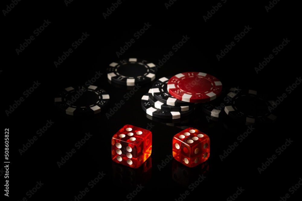 Dice and chips obtained from winnings while playing Craps. The idea of the game on a black background with space for advertising Dice and chips obtained from winnings while playing Craps. The idea of the game on a black background with space for advertising