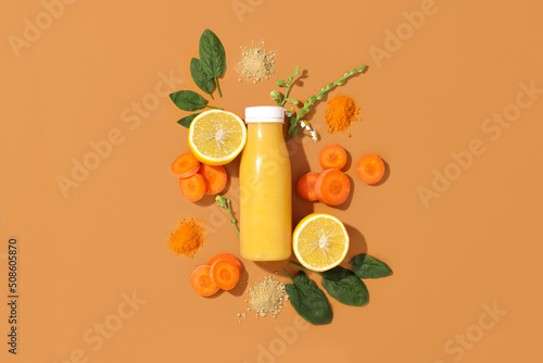 Bottle of fresh smoothie with carrot, vitamin c lemon, spinach, ginger and turmeric. Concept healthy eating, snack to go, breakfast. Flatlay