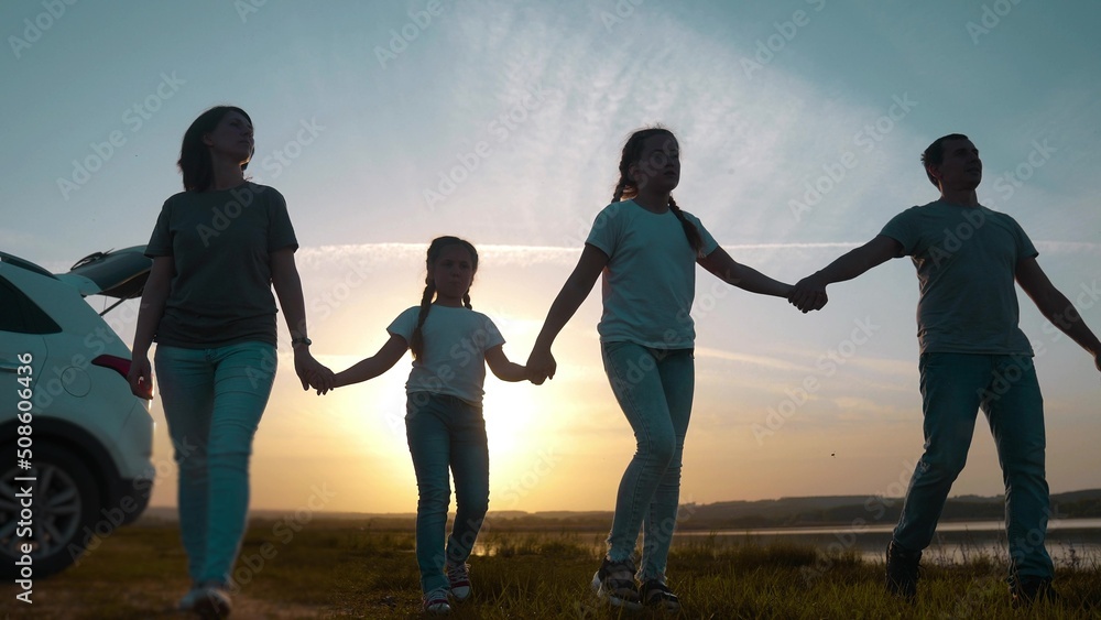 Naklejka premium people in the park. happy family a silhouette walk at sunset. car travel kid dream concept. happy family parents and fun children walk silhouette next to car. family walk next sunset to car