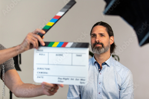 Video Production Movie Slate Being Using in Front of Business Man on Film Set. Focus is Adult Male