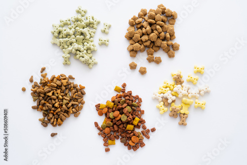 top view of different dry food and tasty treats for pets isolated on white.