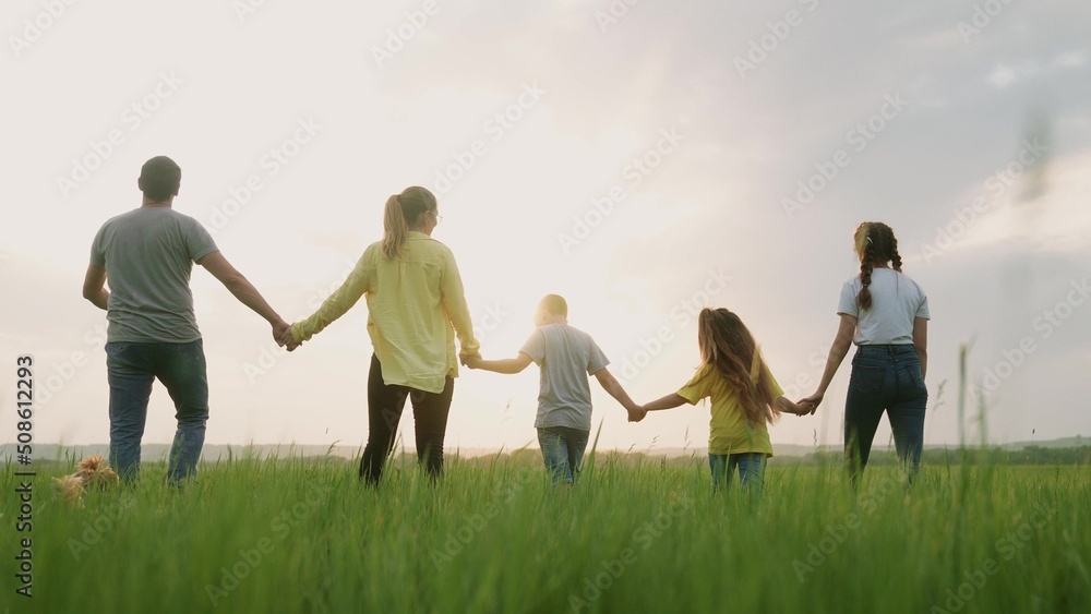 people in the park. happy family a silhouette walk in field. mom dad fun and daughters, son walk holding hands in park. happy family kid dream concept. parents and children walking back silhouette people in the park. happy family a silhouette walk in field. mom dad fun and daughters, son walk holding hands in park. happy family kid dream concept. parents and children walking back silhouette