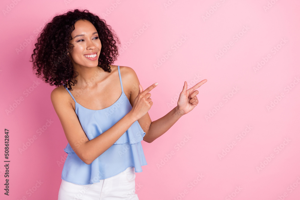 Photo of positive adorable lady look direct fingers empty space blank isolated on pink color background Photo of positive adorable lady look direct fingers empty space blank isolated on pink color background