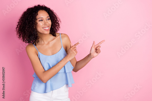 Photo of positive adorable lady look direct fingers empty space blank isolated on pink color background