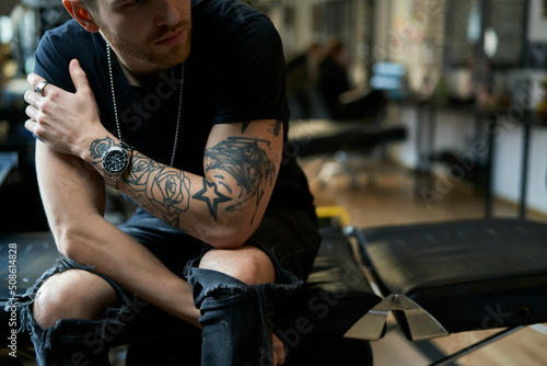 Close up of young adult man of tattoo salon