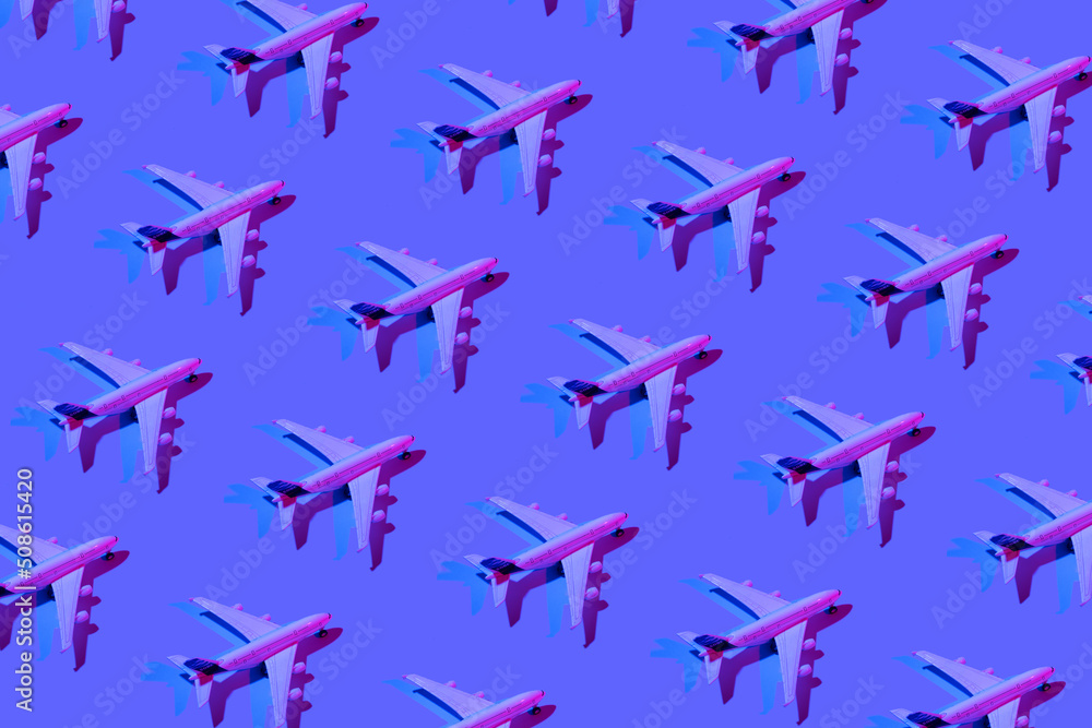 Pattern made of passenger plane toy neon light. Minimalistic concept of air travel, business travel Pattern made of passenger plane toy neon light. Minimalistic concept of air travel, business travel