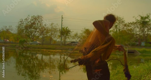 Male Asian farmer and mercenary man with beard who is a poor indigenous man would catch fish with nets to feed his livelihood in natural pools. photo