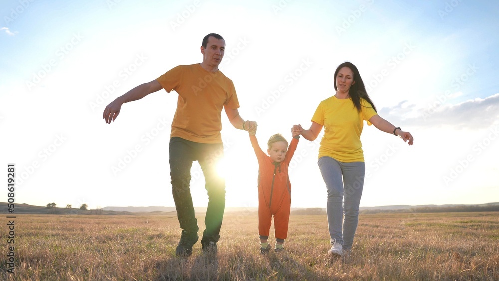 happy family. parent a baby together run in the park at sunset. people in park concept. mom dad daughter fun and son swing on hands joyful run. happy family and baby child summer kid dream concept happy family. parent a baby together run in the park at sunset. people in park concept. mom dad daughter fun and son swing on hands joyful run. happy family and baby child summer kid dream concept