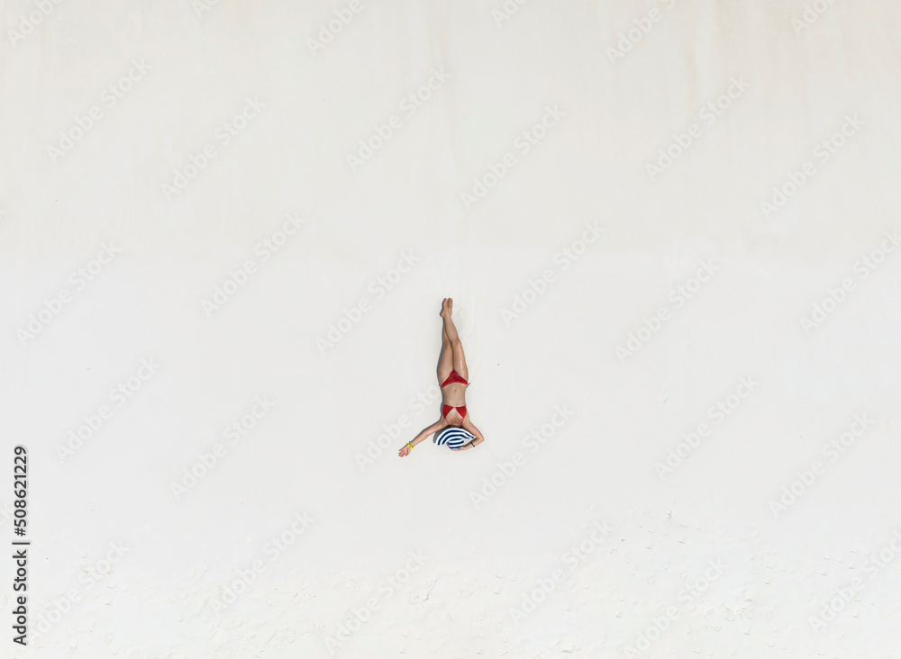 Relax lifestyle with young woman sunbathing as laying on the white sand beach background -Summer fashion concept,top view