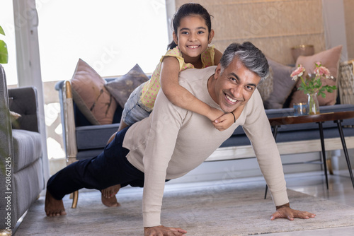 Photography Happy strong father and little daughter enjoying funny activities in living room