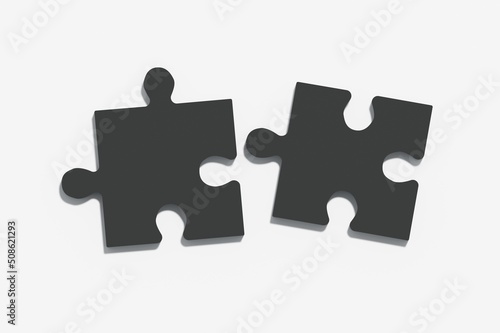 Two black puzzles on a light grey background, the concept of joining or separating something