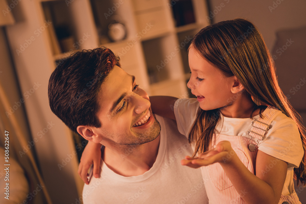 Naklejka premium Photo of adorable funny father small school girl spending time together talking indoors house home room