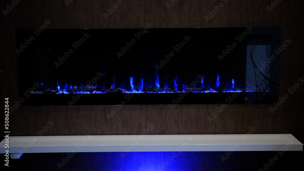 view on electric fireplace with artificial sparkling flame, decor for the interior, blue flame on crystals view on electric fireplace with artificial sparkling flame, decor for the interior, blue flame on crystals