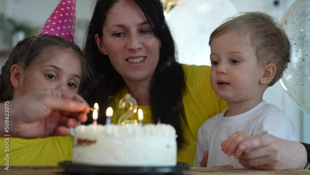 birthday. happy family on holiday party. parents and childs with baby getting ready to blow out birthday cake with candles. happy family at birthday. baby fun blows out the candles on the cake birthday. happy family on holiday party. parents and childs with baby getting ready to blow out birthday cake with candles. happy family at birthday. baby fun blows out the candles on the cake