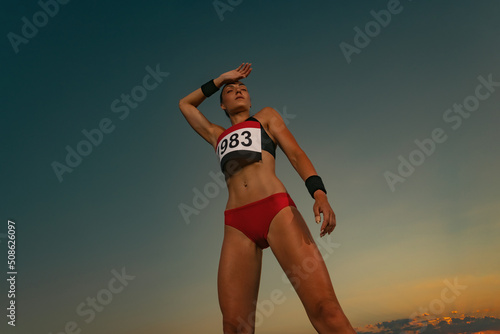 Marathon trail running. Sprinter run. Strong athletic woman running on black background wearing in the sportswear. Runner with competition number on the chest.