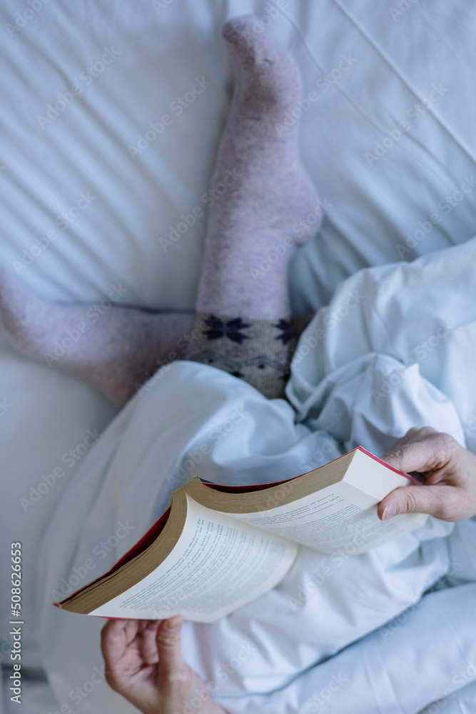 Reading a book in bed - obrazy, fototapety, plakaty 