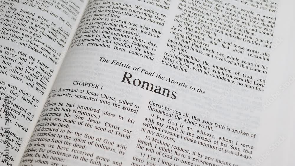 Close Up Shot of Bible Page Turning to the book of Romans Close Up Shot of Bible Page Turning to the book of Romans
