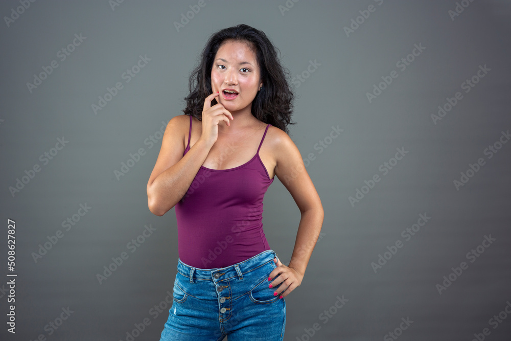 Chinese woman posing flirtatiously on gray background Chinese woman posing flirtatiously on gray background