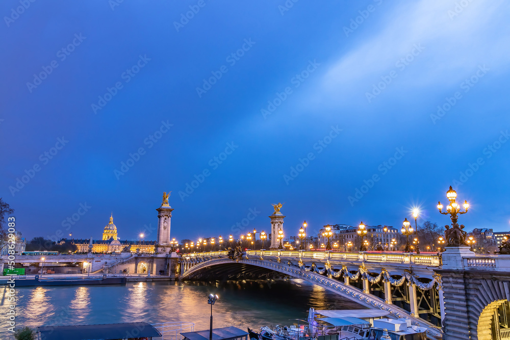 The Pont Alexandre III at night, is a deck arch bridge that spans the Seine in Paris. It connects the Champs-Élysées quarter with those of the Invalides and Eiffel Tower.