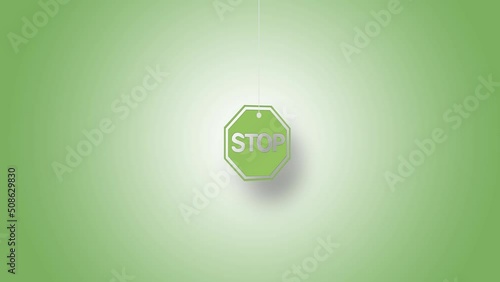 Stop sign in green hanged with strings against green background. High quality video in 4K resolution.