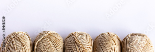 Beige yarn threads on a white background for knitting. Flat lay