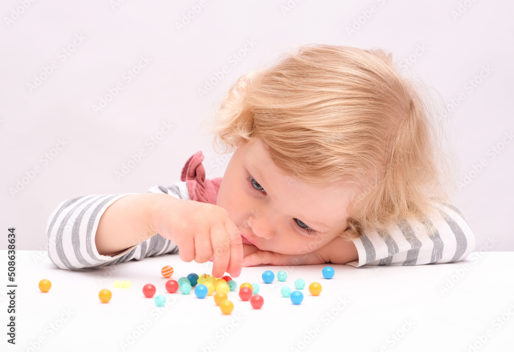 Pretty caucasian little girl plays with beads Pretty caucasian little girl plays with beads