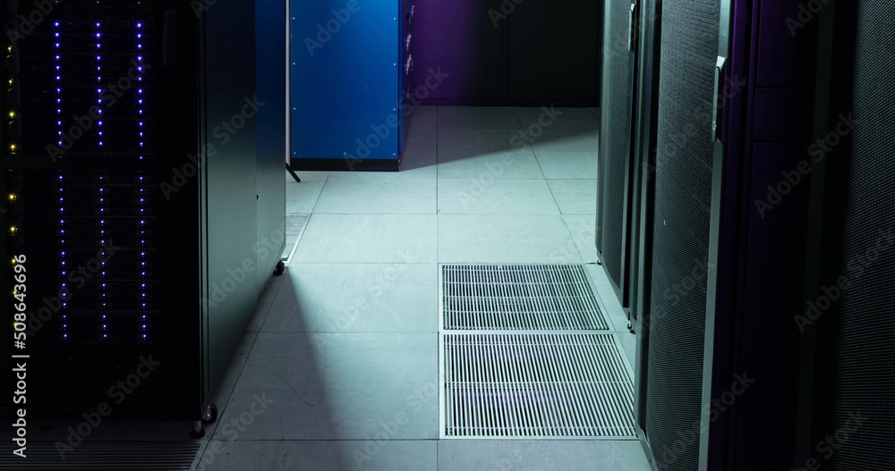 Image of empty corridor with rows of purple and blue computer servers Image of empty corridor with rows of purple and blue computer servers