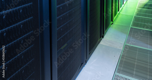 Image of empty corridor with row of green and blue computer servers