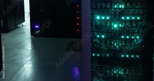 Image of empty corridor with rows of red and green lights in computer servers