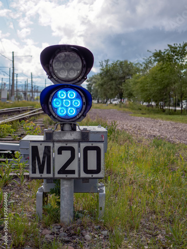 Small two-sections railway shunting semaphore with a colorlight signals near the railway tracks. Blue light photo
