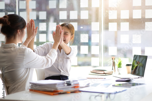 Fotografija Businesswoman and office colleagues express excitement and happiness as the job is accomplished and the bonus is awarded