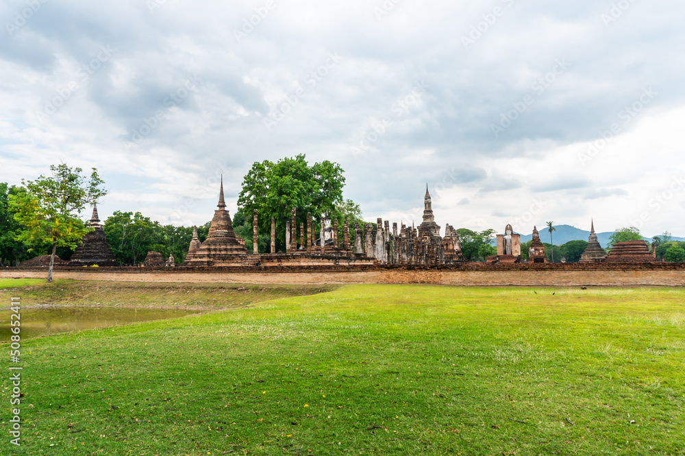 Landscape of Buddha statue and pagoda in Wat Mahathat temple Sukhothai Historical Park, Thailand