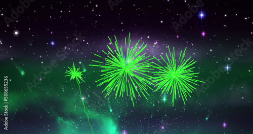 Image of green christmas and new year fireworks exploding in starry cosmos night sky