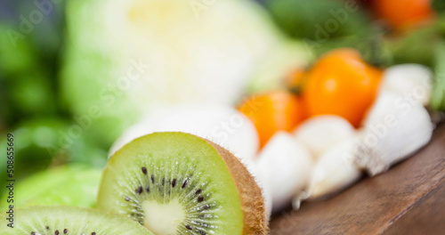 Image of fresh organic vegan food with kiwi fruit and vegetables on wooden boards