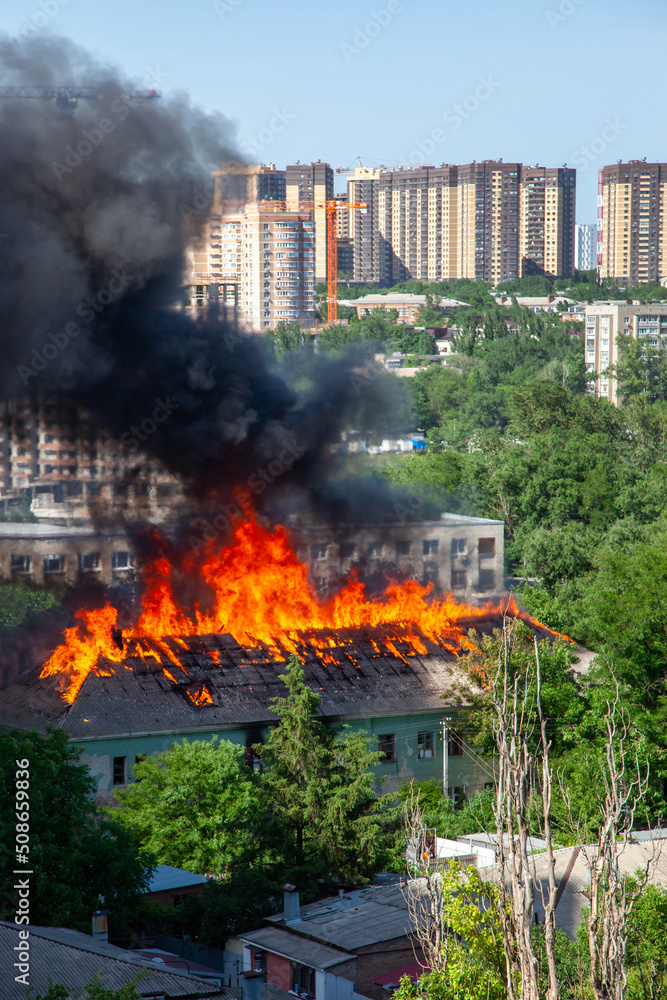 A fire in an old abandoned house, a view from the window of a neighboring high-rise building A fire in an old abandoned house, a view from the window of a neighboring high-rise building