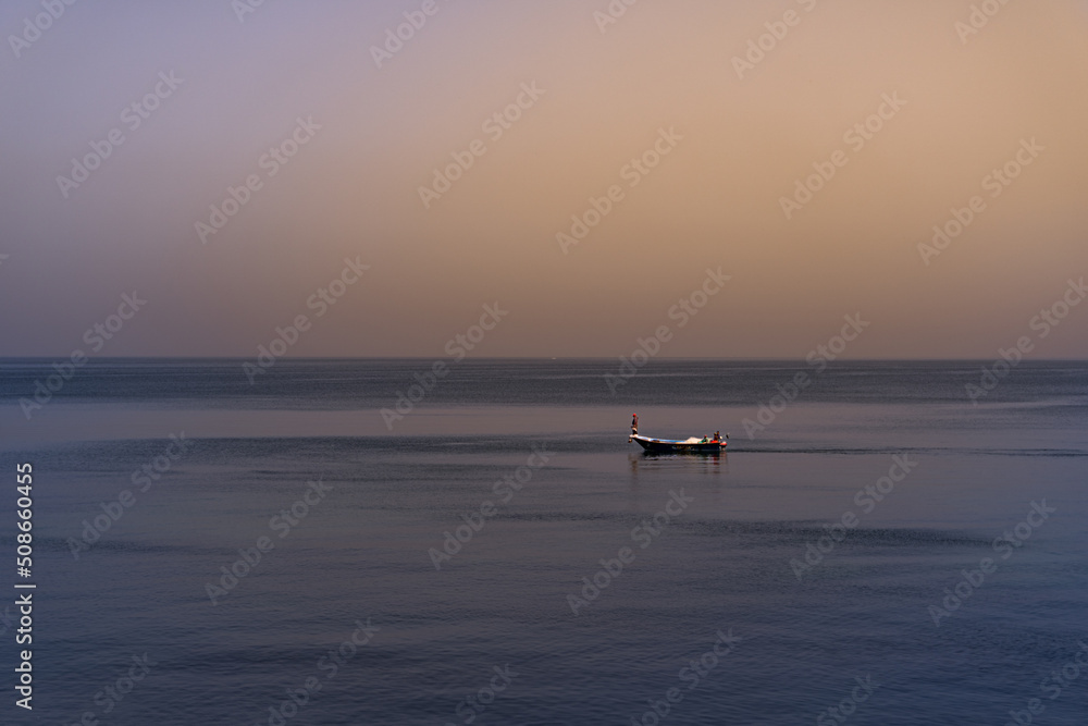 A boat in the middle of the sea at sunset in Alexandria Egypt