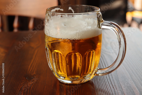 glass with handle full of light beer with foam