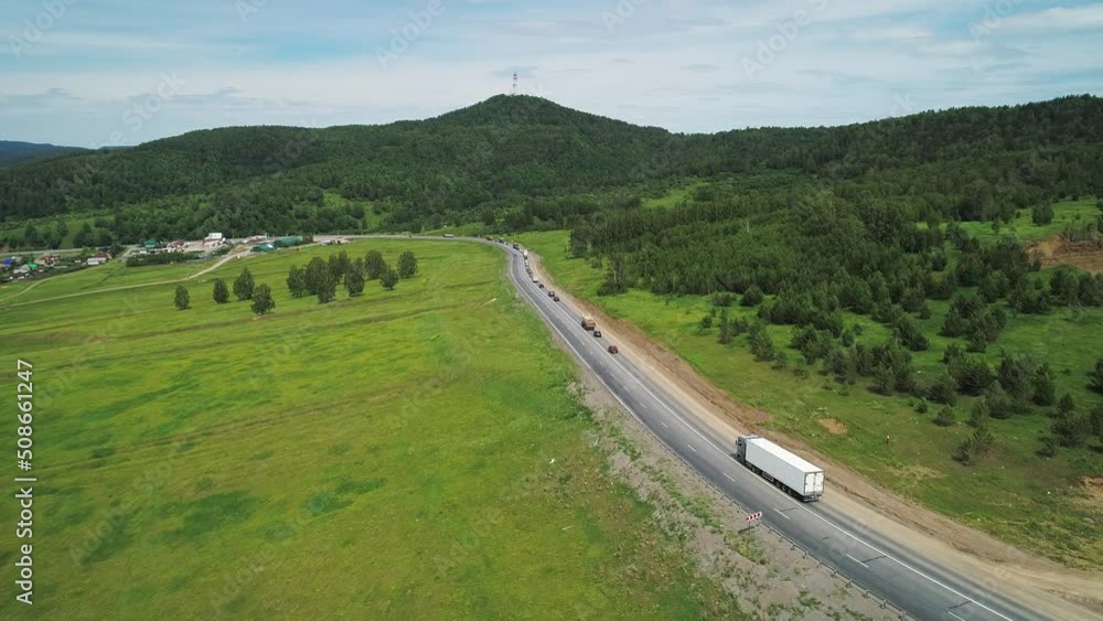 Aerial view of an intercity highway with traffic going through green meadows and trees on a sunny day. Panoramic shot Aerial view of an intercity highway with traffic going through green meadows and trees on a sunny day. Panoramic shot