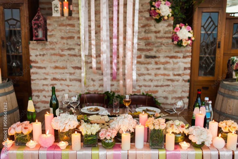 The flowers, candles and colored ribbons on the wedding table