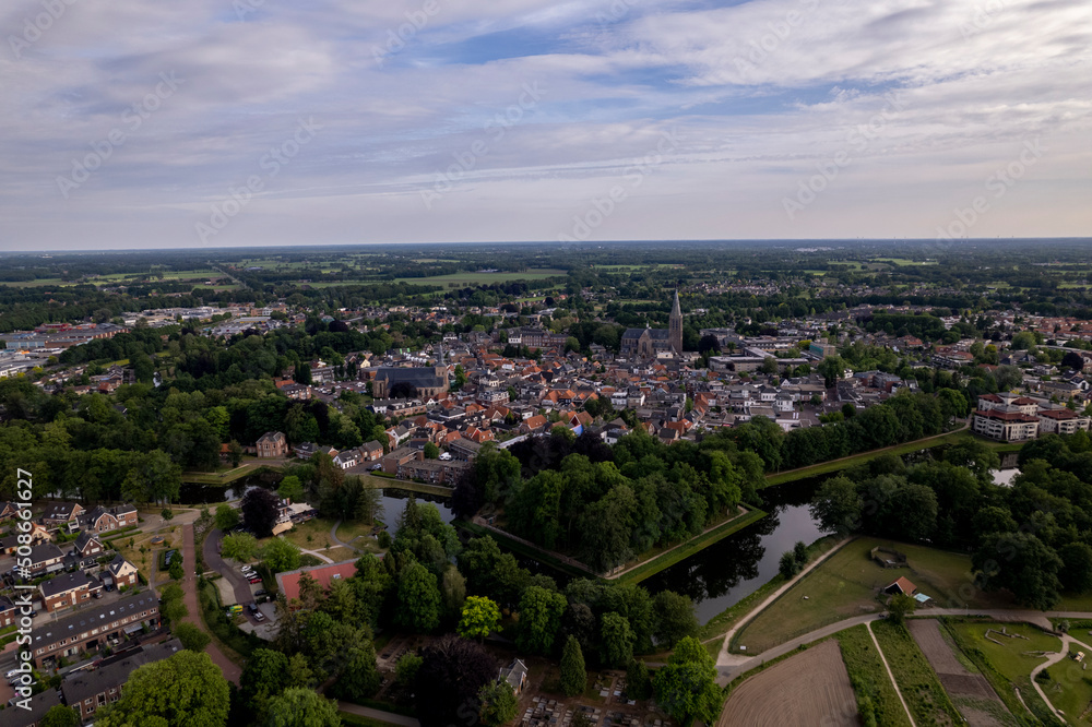 Urban planning, development and housing market concept. Aerial view of historic Dutch city Groenlo with church tower rising above the authentic medieval rooftops and defending moat in  the foreground