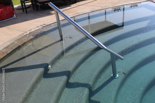 stairs and a railing in the pool on a sunny day