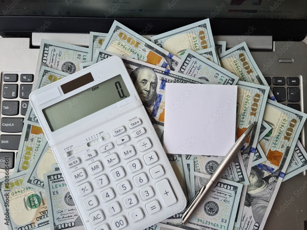 Fototapeta premium Calculator white sticker on one hundred dollar bills on keyboard