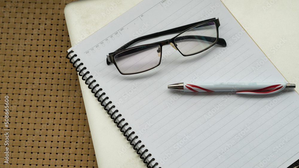 Office desk table and book note with glasses pen top view Office desk table and book note with glasses pen top view